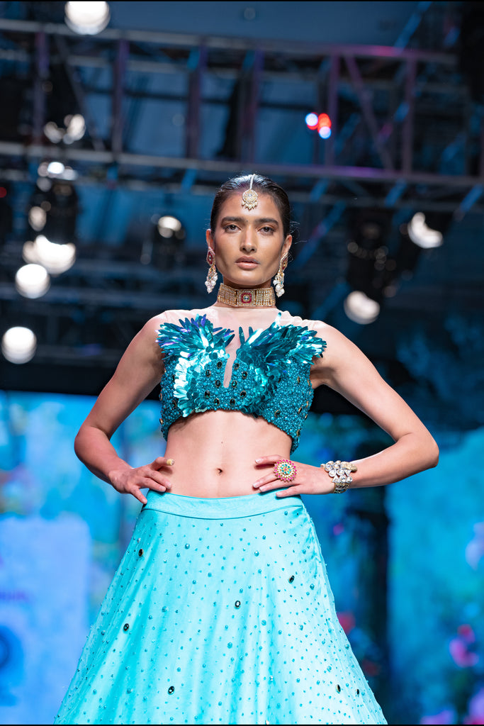 THE DAWN LEHENGA AND METALIC FEATHER SEQUENCE CROP TOP SET IN TEAL BLUE